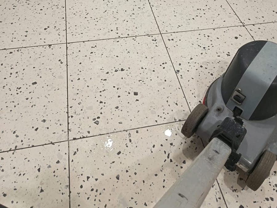 Monobrosse sur un sol en granito mouillé dans des sanitaires de locaux
